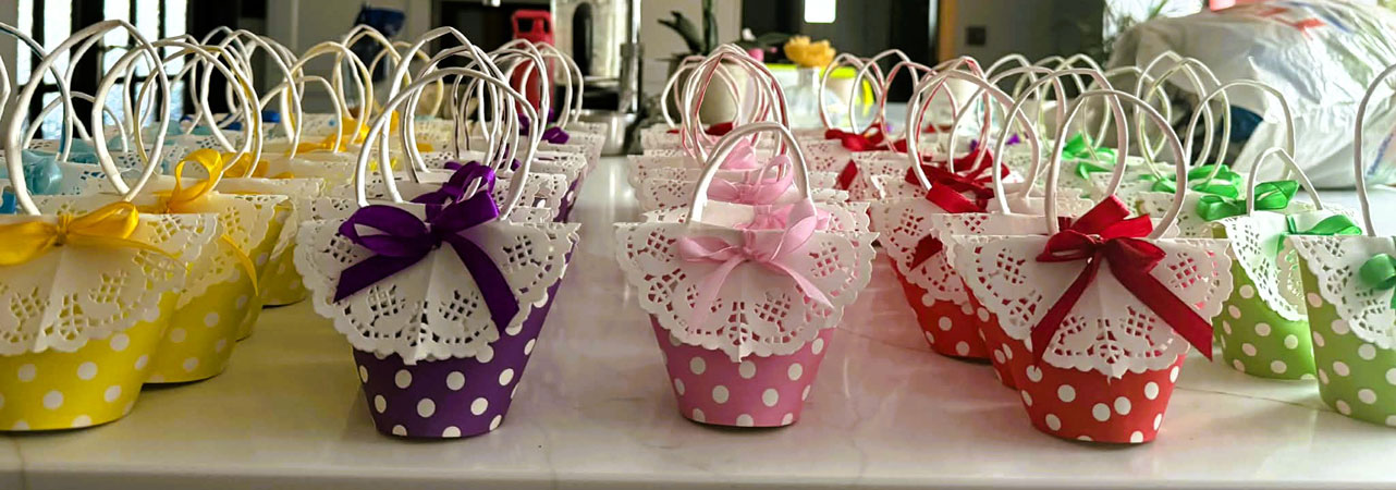 Lots of cardboard baskets of different colours, decorated for Easter