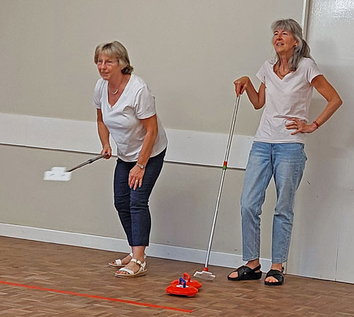 Two ladies get ready to play curling